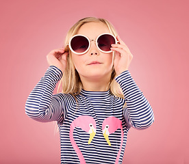 Image showing Studio, portrait of small girl with sunglasses and fun clothes on vacation isolated on pink background. Summer, holiday and cool fashion clothing, happy child in Australia for travel and adventure