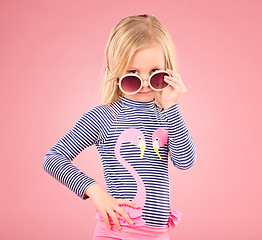 Image showing Holiday, portrait of child in studio with sunglasses and fun clothes isolated on pink background. Summer, vacation and fashion for children, girl in Australia on travel in serious face and beachwear