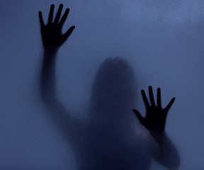 Image showing Horror, mystery and shadow of a woman on a window for fear, escape or nightmare. Dark, hands and a ghost, girl or person with paranormal activity, spooky behavior or strange movement in a studio