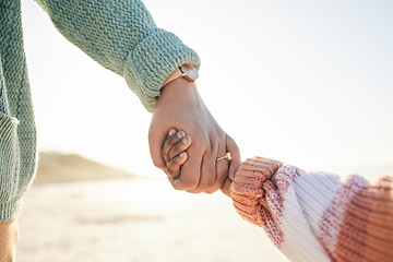 Image showing Family, mother and kid holding hands at beach, travel and summer holiday with sunshine and together outdoor. Trust, support with woman and girl on vacation, love and care in nature with closeup