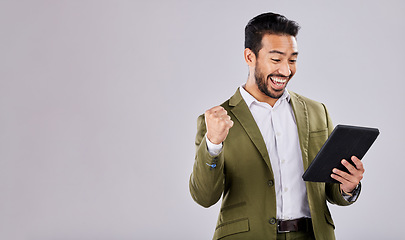 Image showing Businessman, tablet or success fist on isolated studio background for financial growth, stock market deal or mock up security. Smile, happy or cheering asian man with winner hands, technology or loan