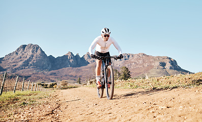 Image showing Man, mountains and cycling on trail in nature, countryside and blue sky for triathlon sports in Cape Town. Cyclist, bicycle and off road path outdoor for fitness, bike exercise and energy in sunshine