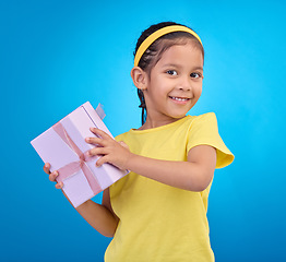 Image showing Gift, happy and smile with portrait of girl for celebration, shopping and birthday event. Happiness, surprise and present with child for party, giveaway and products isolated on blue background