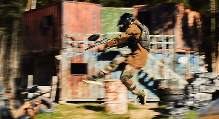 Image showing Paintball, man jump and aim gun at target, military tactics at shooting range and war game for sports outdoor. Soldier with weapon on battlefield, action and camouflage, motion blur and adventure