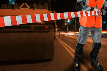 Image showing Worker blocks repair street.