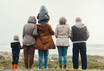 Image showing Back, love and family on beach, morning and quality time for break, vacation and cheerful together. Grandparents, mother and father with siblings, children and seaside holiday to relax, cold and rest