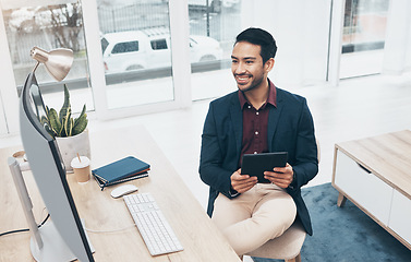 Image showing Office, Indian man at desk with tablet and smile at computer, reading good news email or successful sales report online. Business, smile and communication with internet research, social media or web.