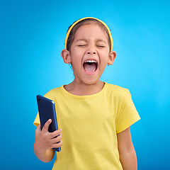 Image showing Phone, scream and child on blue background with attitude, upset and lose online game, network or internet. Technology, bad behaviour and face of girl upset, angry and shout with smartphone in studio