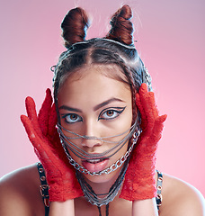 Image showing Chains, fashion and face of goth woman with unique style isolated against a studio pink background. Portrait, accessories and edgy female model metal jewelry on her head and cool makeup