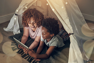 Image showing Black family, tablet and mother with kid in tent at night watching movie, video and having fun in home. Technology, bokeh and smile of happy African mom bonding with boy child while streaming film