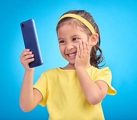 Image showing Wow, excited and girl with smartphone, social media and cheerful kid against a blue studio background. Latino female, happy young person and cellphone with connection, happiness and watching video