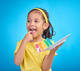 Image showing Happy, tasting and girl with cake, excited and cheerful against blue studio background. Young person, Latino female child and kid with dessert, happiness or cheerful with licking finger and celebrate