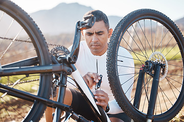 Image showing Repair, tools and check with man and mountain bike for fitness, training or exercise in nature. Cycling, sports and adventure with cyclist fixing bicycle on trail for gears, maintenance or inspection