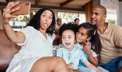 Image showing Family, funny face and selfie with tongue out in home, having fun and bonding together. Interracial, comic photography and father, mother and girls taking pictures for social media and happy memory.