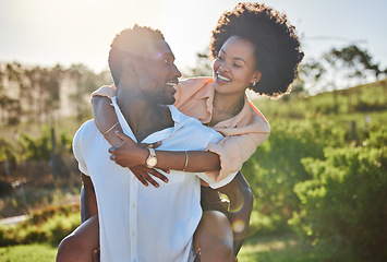 Image showing Black couple, piggy back or bonding in park, nature garden or sustainability environment in fun activity game or love. Smile, happy man or afro woman in carry support, trust or freedom playful date