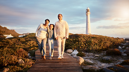 Image showing Happy, beach and girl with grandparents on boardwalk for travel vacation, bonding or sunset. Lighthouse, summer break and commitment with child and senior couple walking for support, positive or care