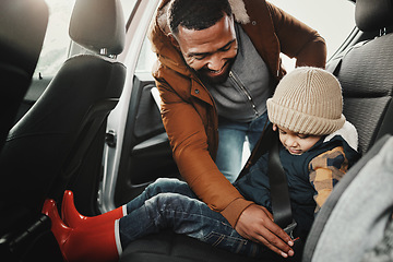 Image showing Father help child fasten seat belt leaving for vacation, trip or holiday in a car before travel together. Transport, transportation and dad or parent with kid in a vehicle for a getaway