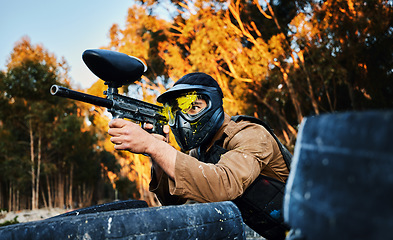 Image showing Paintball man with gun shooting target in forest battlefield, competition or games for fun adventure training. Aiming skill of male player or sports person in military focus or woods survival mission