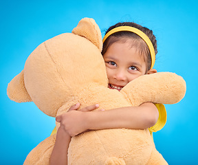 Image showing Mockup, portrait and girl with teddy bear, hug and happiness against a blue studio background. Face, female kid and young person embrace fluffy toy, cheerful and child development with fun and joy