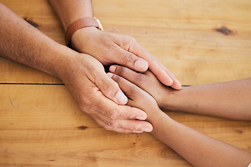 Image showing Top view of couple holding hands on table for love, care and empathy of mental health, trust and counseling. Closeup people, helping hand and support on wooden surface for gratitude, kindness or hope