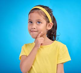 Image showing Thinking, idea and face of child in studio with contemplation, thoughtful and planning expression. Ideas mockup, innovation and young girl on blue background for brainstorming, question and curious