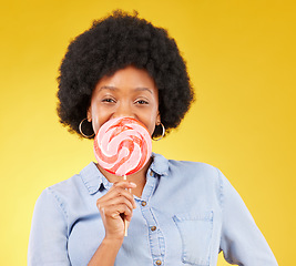 Image showing Sweets, candy and lollipop with black woman in studio for colorful, cheerful and positive. Young, happiness and dessert with female isolated on yellow background for treats, food and confectionary