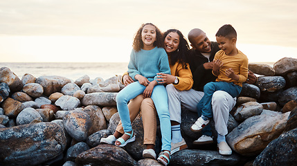 Image showing Adventure, beach and family relaxing on rocks while on summer vacation, travel or weekend trip. Sunset, portrait and parents bonding with their children by the ocean while on seaside tropical holiday