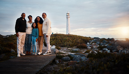 Image showing Big family, portrait walking and nature bonding on a holiday at sunset by a sea lighthouse. Ocean, beach walk and outdoor with a mom, father and child together with love and parents support at dusk