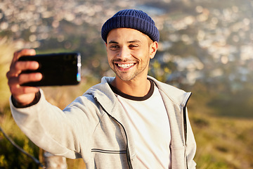 Image showing Fitness, selfie and male hiking on the mountain after walking for a wellness exercise in nature. Sports, health and young man hiker taking a picture while trekking outdoor for a cardio workout.