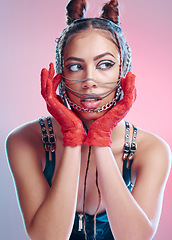 Image showing Punk, rock chains and red gloves of a woman with makeup, bondage and bdsm style in a studio. Isolated, pink background and metal aesthetic of a gen z person and hispanic model with rocker clothing