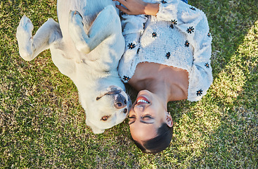 Image showing Happy, woman and dog relax on grass with peace and outdoor fun in park, nature and hug pet with love and care. Animal with human bonding top view, Labrador puppy and happiness in countryside.