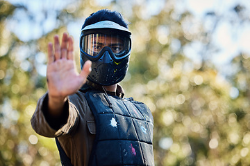 Image showing Man, paintball and hands in stop signal for team communication or strategy on the battlefield in nature. Male paintballer or soldier showing hand sign halt or wait in adrenaline sport outdoors