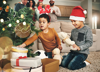 Image showing Christmas, happy and children opening gifts, looking at presents and boxes together. Smile, festive and kids ready to open a gift, or present under the tree for celebration of a holiday at home