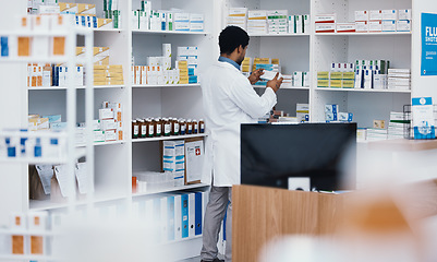 Image showing Black man pharmacist, pharmacy stock check and employee in a wellness, healthcare and drugs clinic. Reading, medical information and a retail pharmaceutical worker with pills storage and supplements