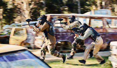 Image showing Team, paintball and army moving on the attack in extreme adrenaline sport, battle or war in the nature outdoors. Group of paintballers or soldiers in rush aiming down sights in teamwork engagement