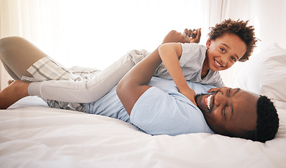 Image showing Children, love and bedroom with a playful black family having fun in the morning together after waking up. Kids, smile or laughing with a father and happy son playing or joking on a bed in their home