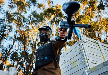 Image showing Paintball, gun and violence with a sports man on a battlefield for military or war training for the army. Fitness, team building and safety with a male athlete or soldier playing a game outdoor