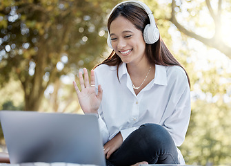 Image showing Laptop, wave and business woman in video call with headphones outdoors in park. Computer, hello and happy female entrepreneur, remote worker or freelancer waving in virtual chat, webinar or meeting.