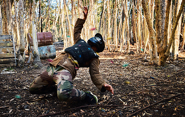 Image showing Man, paintball and dodging shots in the matrix for intense battle or war in the forest on knees. Male paintballer or soldier ducking to dodge paint balls in extreme adrenaline sports outdoors
