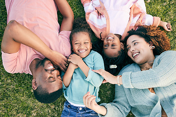 Image showing Top view, happiness and black family on grass, quality time and carefree in park, break and smile. Mother, father and children in backyard, cheerful and playful together for bonding, loving and relax