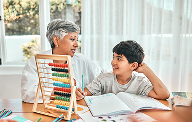 Image showing Grandma help, child abacus learning and home studying in a family house with education and knowledge. Senior woman, boy and teaching of a elderly person with a kid doing writing for a class project