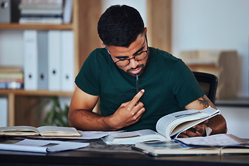 Image showing Student, black man and books to study on home desk thinking, reading and studying for college. Person learning and focused on information on page for education, knowledge and working on law research