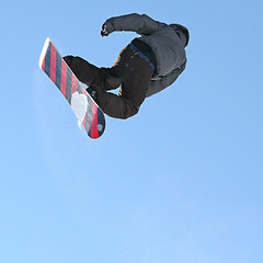 Image showing Snowboarder jumping high in the air