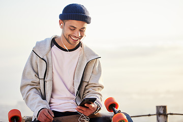 Image showing Skateboarder, phone and man streaming music, audio or podcast online and relax after skating with mockup and texting. Skater, skateboard and person listening to mobile radio in sunset on social media