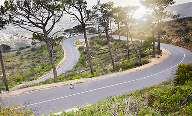 Image showing Mountains, skateboard and fitness with man on winding road for training, speed and adventure. Freedom, youth and fast with guy skating in urban street of nature for exercise, wellness and challenge