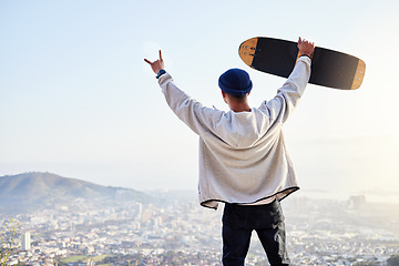 Image showing Skateboard, winner and mountains with man cheering for fitness, sports and adventure. Happiness, success and training with gen z guy and hands up in outdoors for skating, wellness and summer break