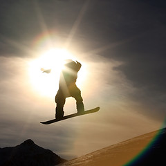 Image showing Snowboarder jumping high in the air