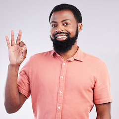 Image showing Portrait, perfect and hand gesture with a black man in studio on a gray background to say magnifique. Emoji, communication and okay with a happy or handsome young male speaking in sign language