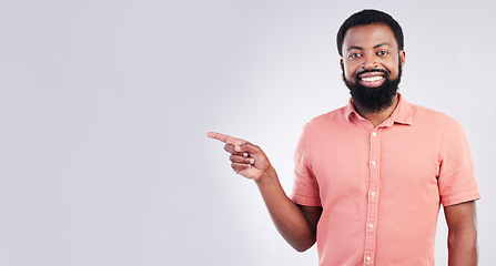 Image showing Point, mockup space and portrait of black man with hand gesture for product placement, advertising and sign. Happy, studio and male smile on white background pointing for choice, branding and showing