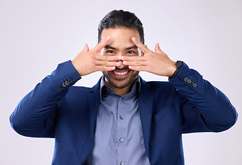 Image showing Asian man, business and hands for eyes and smile in studio for motivation and pride while peeking. Happy male model portrait isolated on a gray background as corporate leader with a positive mindset